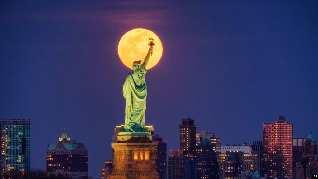 In this March 9, 2020, file photo, the full moon rises behind the Statue of Liberty in New York. (AP Photo/J. David Ake, File)